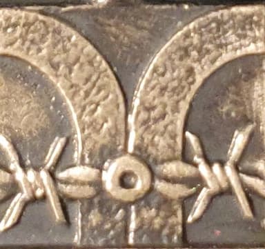 Charakterystyczne, wygięte betonowe słupy z drutami kolczastymi