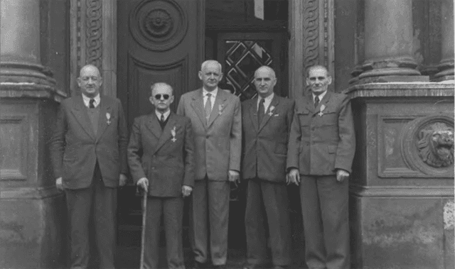 Fotografia przedstawiająca powstańców wielkopolskich po uroczystości dekoracji Wielkopolskim Krzyżem Powstańczym nadanym przez Radę Państwa weteranom Powstania Wielkopolskiego na sesji Rady Narodowej m. Krakowa 06.03.1958r. źródło: https://www.wbc.poznan.pl/dlibra/publication/81875/edition/95886/content